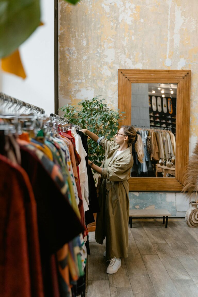 A stylish woman browsing clothes in a trendy boutique with wooden decor.