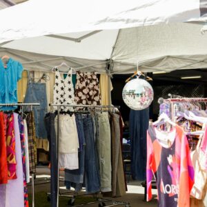 Vibrant outdoor clothing bazaar with various garments on display in Los Angeles, CA.