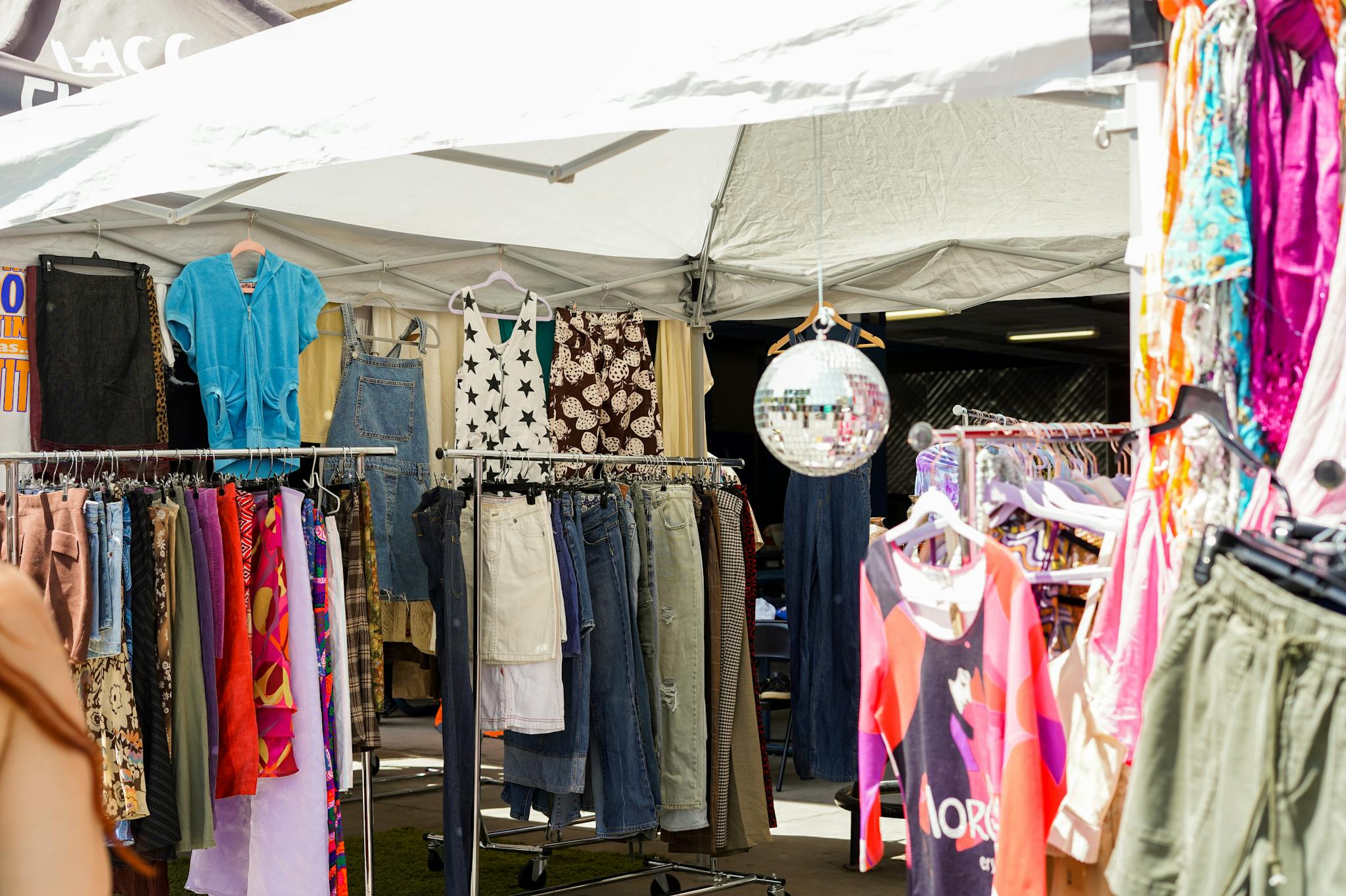Vibrant outdoor clothing bazaar with various garments on display in Los Angeles, CA.