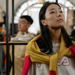 Young woman browsing a trendy clothing store, reflecting urban shopping culture.